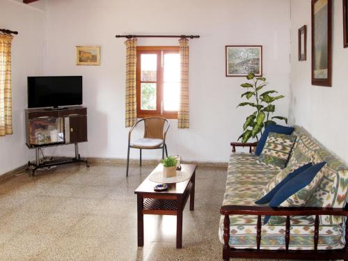 a living room with a couch and a tv at Holiday Home Sa Caseta by Interhome in Cala Santanyi