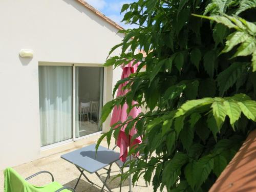 a chair sitting on a patio next to a tree at Holiday Home La Touche - IDR120 by Interhome in La Flotte