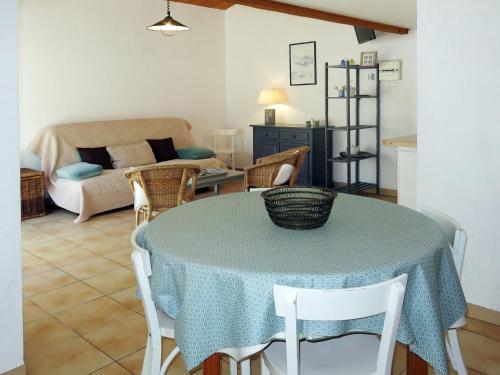 un salon avec une table avec des chaises et un canapé dans l'établissement Holiday Home La Touche-3 by Interhome, à La Flotte