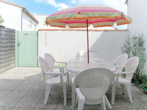 une table et des chaises avec un parasol sur une terrasse dans l'établissement Holiday Home La Touche-3 by Interhome, à La Flotte