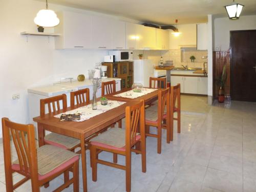 a kitchen with a wooden dining table and chairs at Holiday Home Helena - Pag310 by Interhome in Pag