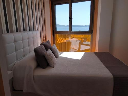 a bedroom with a bed with a large window at Apartamento Sanxenxo Carles Deluxe Ocean View in Sanxenxo