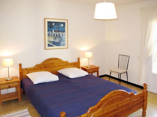 - une chambre avec un grand lit en bois et 2 oreillers dans l'établissement Apartment Villa Montemare Babette by Interhome, au Lavandou