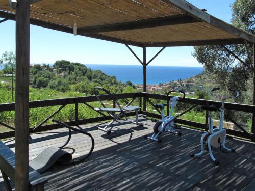 zwei Heimtrainer auf einer Terrasse mit Meerblick im Hintergrund in der Unterkunft Holiday Home Le Terrazze del Geco Bungalow A - SLR300 by Interhome in San Lorenzo al Mare