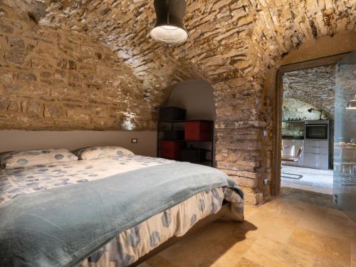 ein Schlafzimmer mit einer Steinmauer und einem Bett in einem Zimmer in der Unterkunft Apartment Mulino by Interhome in Montegrazie