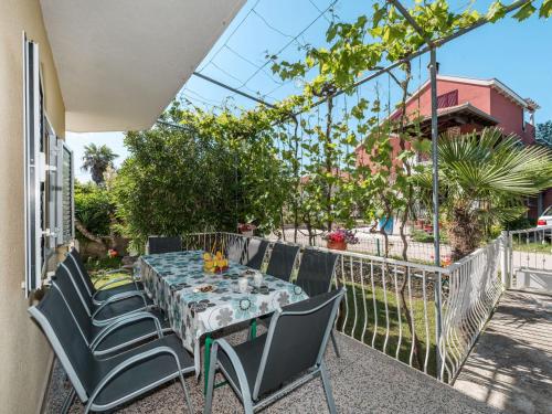 a patio with a table and chairs and a fence at Apartment Šime - ZAD505 by Interhome in Sukošan