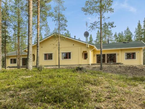 une maison jaune dans les bois avec des arbres dans l'établissement Holiday Home Sallan saaga by Interhome, à Tikkala