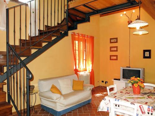 ein Wohnzimmer mit einem Sofa und einer Treppe in der Unterkunft Holiday Home Il Casello by Interhome in Sillano