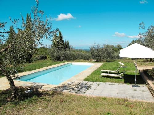 a swimming pool with a bench and an umbrella at Holiday Home Il Casino by Interhome in San Donato in Poggio
