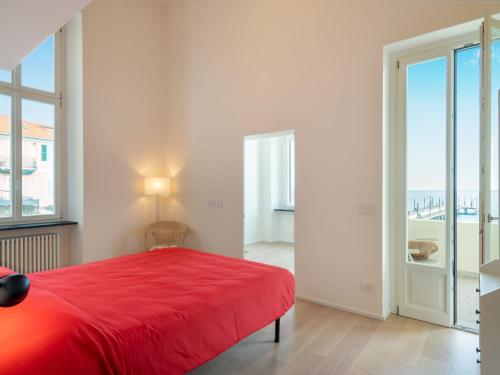 a bedroom with a red bed and a large window at Apartment Terrazza sul Molo by Interhome in Alassio
