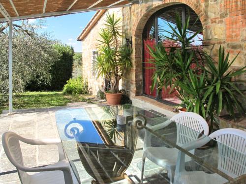 einen Glastisch und Stühle auf einer Terrasse in der Unterkunft Holiday Home Il Casino by Interhome in San Donato in Poggio