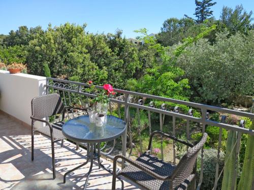 einen Terrassentisch mit Stühlen und eine Blume auf dem Balkon in der Unterkunft Holiday Home Maslina - TGR616 by Interhome in Voluja
