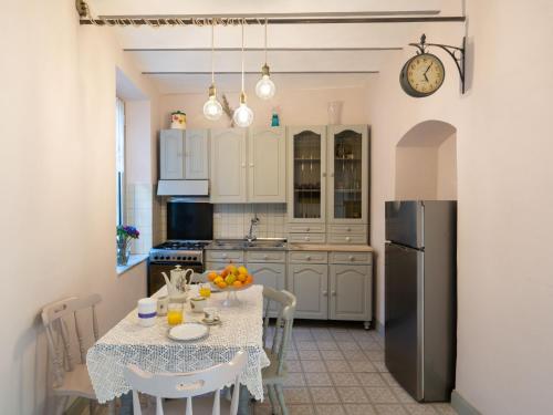 kuchnia ze stołem i lodówką w obiekcie Apartment Caruggiu - PTB193 by Interhome w mieście Pietrabruna