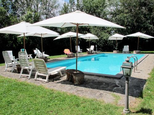einen Pool mit Stühlen und Sonnenschirmen sowie einem Tisch und Stühlen in der Unterkunft Apartment La Capraccia-7 by Interhome in Bagnoregio