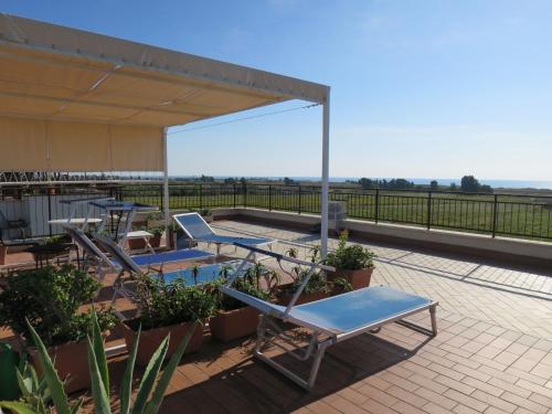 a patio with chairs and tables on a roof at Apartment Algamarina by Interhome in Cerveteri