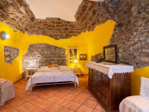 a bedroom with a bed and a stone wall at Apartment Limone by Interhome in Dolcedo