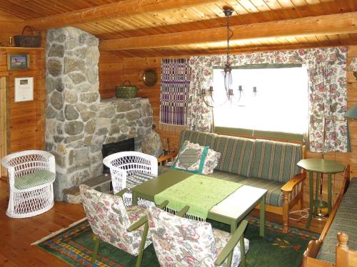 ein Wohnzimmer mit einem Tisch und Stühlen sowie einem Steinkamin in der Unterkunft Chalet Fjellro - FJS103 by Interhome in Holsen