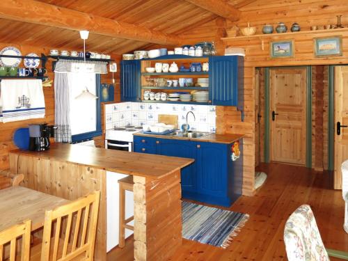 eine Küche mit blauen Schränken und Holzböden in der Unterkunft Chalet Fjellro - FJS103 by Interhome in Holsen