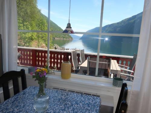 a table with a vase of flowers on a window sill at Holiday Home Njord by Interhome in Arnefjord