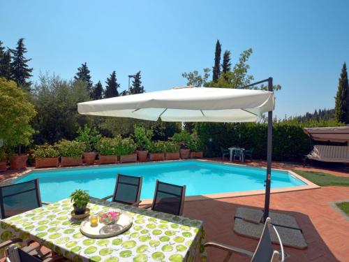 uma mesa com um guarda-sol ao lado de uma piscina em Holiday Home Villa Lucia by Interhome em San Martino