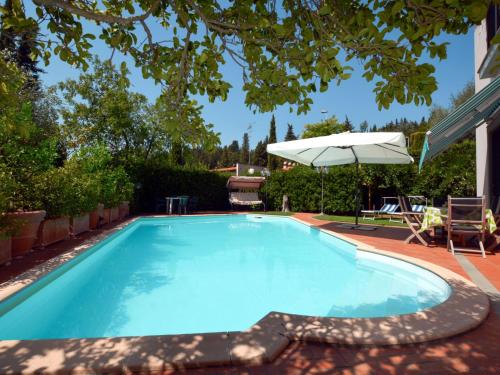 - une piscine avec un parasol, une table et des chaises dans l'établissement Holiday Home Villa Lucia by Interhome, à San Martino