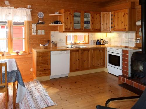 a kitchen with white appliances and wooden cabinets at Holiday Home Jambueggi by Interhome in Arnefjord