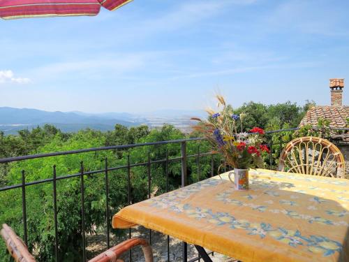 uma mesa com um vaso de flores numa varanda em Apartment Torretta - Borgo la Civitella by Interhome em Roccastrada