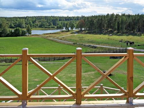 una valla de madera con un campo y un caballo a lo lejos en Holiday Home Örnshult - SND155 by Interhome en Ankarsrum