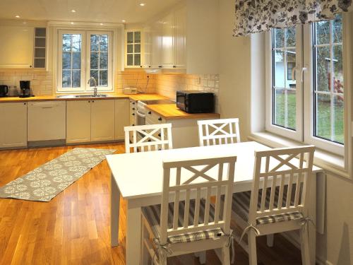 uma cozinha com uma mesa branca e cadeiras em Holiday Home Örnshult - SND155 by Interhome em Ankarsrum