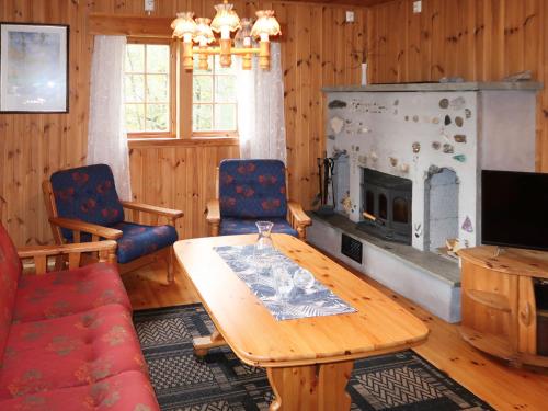 sala de estar con mesa y chimenea en Chalet Skogstjerna - FJS085 by Interhome en Viksdalen