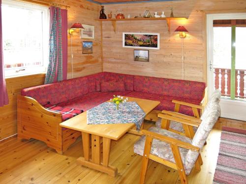 - un salon avec un canapé rouge et une table dans l'établissement Chalet Espetveit - SOO351 by Interhome, à Hornnes