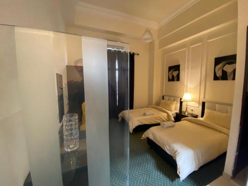 a hotel room with two beds and a mirror at City Citadel Hotel,Amman in Amman