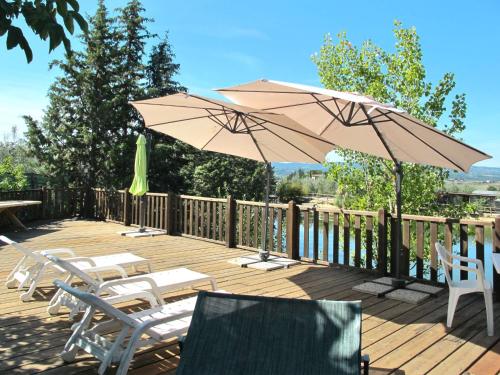 una terrazza in legno con sedie e ombrelloni di Apartment Belvedere - CET122 by Interhome a Luia