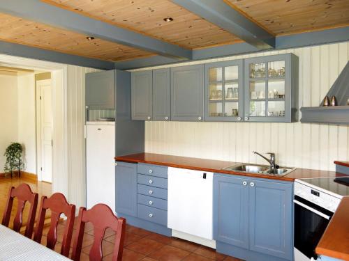 a kitchen with blue cabinets and white appliances at Holiday Home Haven - SOO334 by Interhome in Birkeland