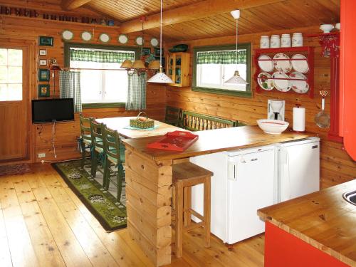 eine Küche mit einer Insel in einer Hütte mit Holzwänden in der Unterkunft Chalet Fjellbris - FJS106 by Interhome in Holsen
