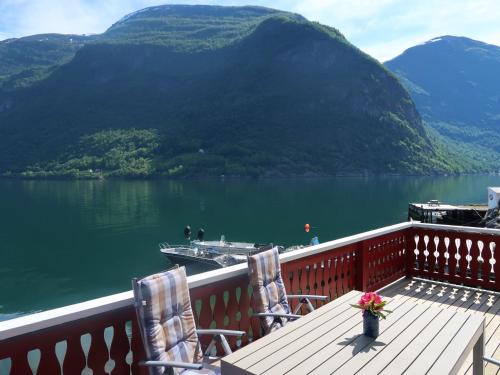 eine Terrasse mit Stühlen und einem Boot im Wasser in der Unterkunft Holiday Home Heimdall - FJS604 by Interhome in Arnefjord
