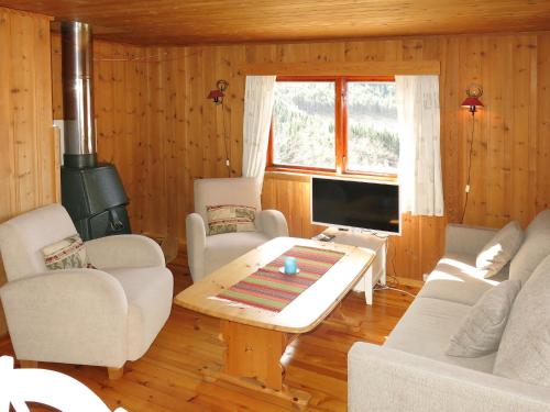un soggiorno con divano, tavolo e TV di Holiday Home Hammaren - FJS771 by Interhome a Kaupanger