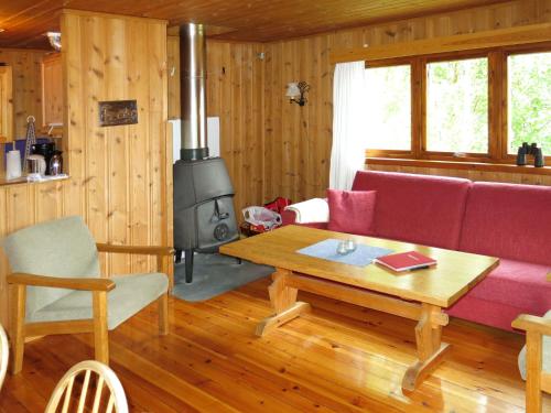 salon z kanapą i piecem opalanym drewnem w obiekcie Holiday Home Turken - FJS767 by Interhome w mieście Kaupanger