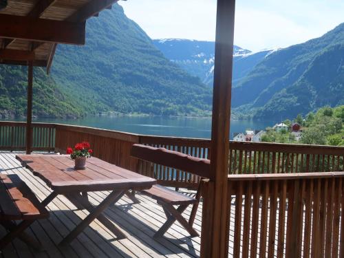 eine Holzterrasse mit einem Tisch und Seeblick in der Unterkunft Holiday Home Odin - FJS608 by Interhome in Arnefjord
