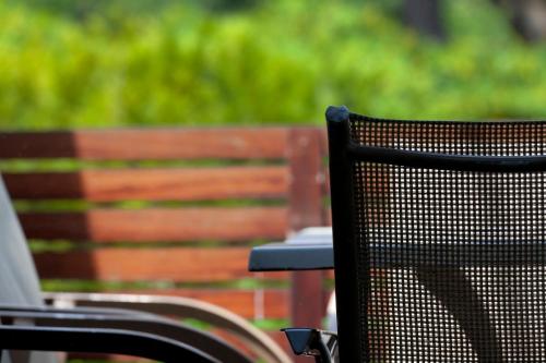 a black chair sitting next to a wooden bench at Hotel Rio Bidasoa in Hondarribia