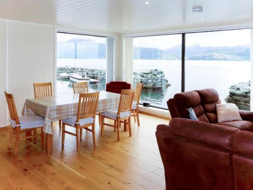 un soggiorno con tavolo, sedie e divano di Holiday Home Kyrkjestein - FJS556 by Interhome a Naustdal i Sunnfjord