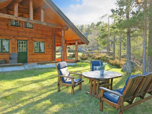 a patio with chairs and a table in front of a cabin at Holiday Home Steinbu - SOW063 by Interhome in Øyuvstad