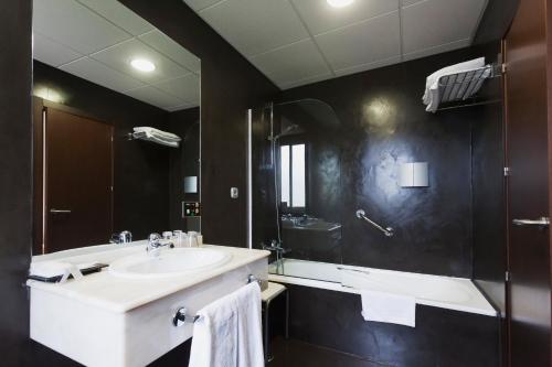 a bathroom with a sink and a bath tub at Hotel Rio Bidasoa in Hondarribia