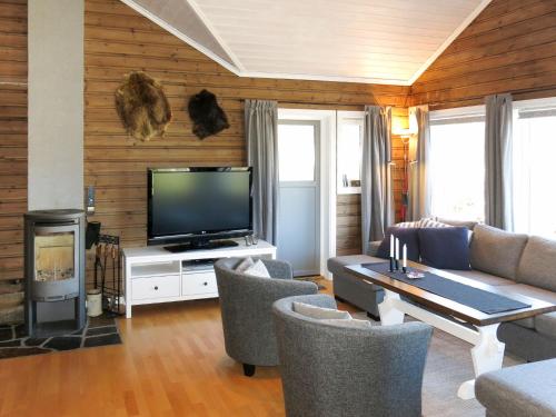 sala de estar con TV, mesa y sillas en Holiday Home Utsikten - SOW134 by Interhome en Tjaldal