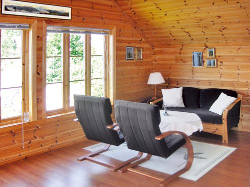 een woonkamer met een bank en een tafel en stoelen bij Chalet Hardangerrorbu - FJH411 by Interhome in Tjoflot