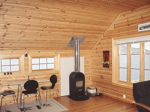 a room with a stove in a log cabin at Chalet Hardangerrorbu - FJH411 by Interhome in Tjoflot