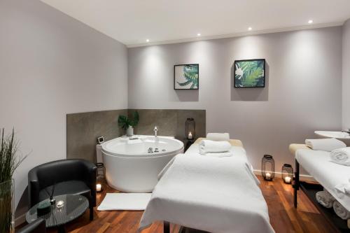 a room with two beds and a bath tub at Radisson Blu Hotel Wroclaw in Wrocław