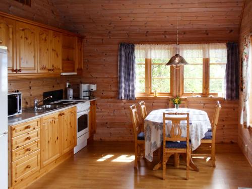 een keuken met een tafel en stoelen in een huisje bij Chalet Eiknes - FJH412 by Interhome in Tjoflot