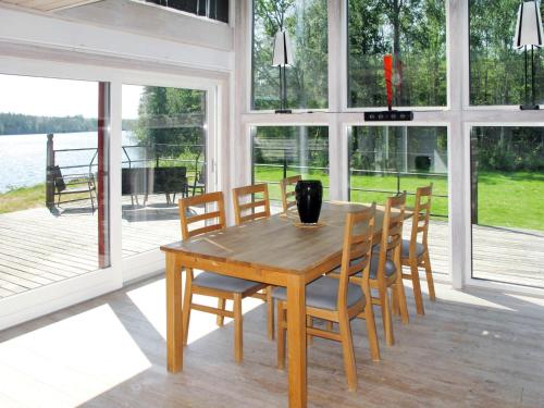 a dining room with a wooden table and chairs at Holiday Home Hoka Villan - B in Asarum