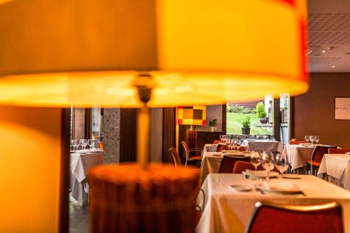 a dining room with tables and chairs and a yellow umbrella at Hotel Rio Bidasoa in Hondarribia